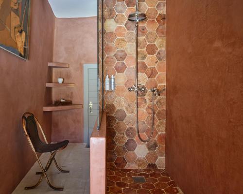 a bathroom with a shower with a chair in it at Villa Syrah, La Bastide de Marie, Villa avec services in Ménerbes
