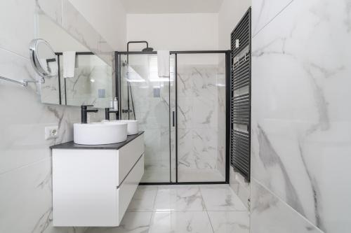 Un baño blanco con ducha y lavabo. en Appartamento in Duomo - Piatti, en Milán