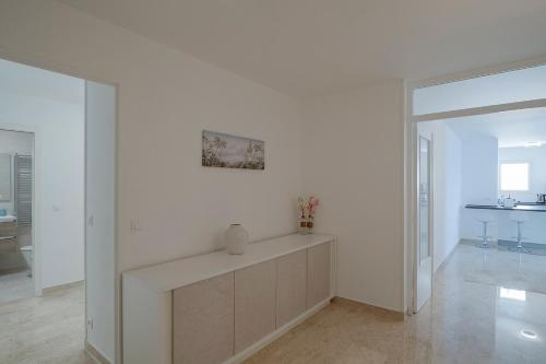 une pièce blanche avec un mur blanc avec un vase dessus dans l'établissement Stylish Apartment S8329, à Roquebrune-Cap-Martin