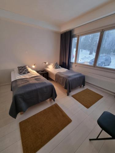 a bedroom with two beds and a large window at Kotimaailma Apartments Kuopio in Kuopio