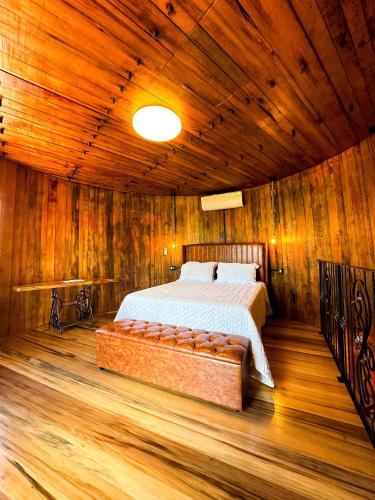 a bedroom with a bed in a wooden room at Villa montebello Pousada Tanoeiro in Monte Belo
