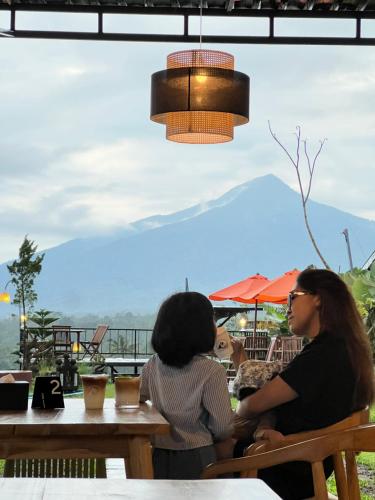 two women sitting at a table in a restaurant at KA MANIcamp in Angsri