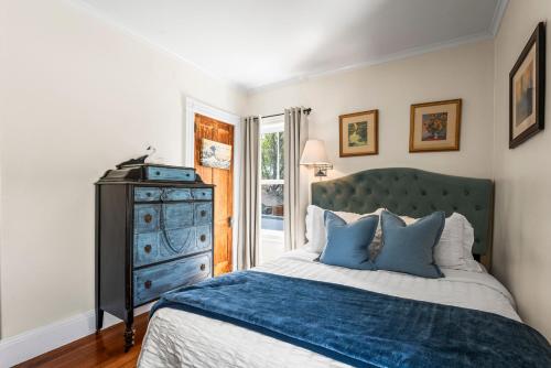 a bedroom with a blue bed and a dresser at Historic Seaside Downtown Mystic Home Walk to Seaport in Stonington
