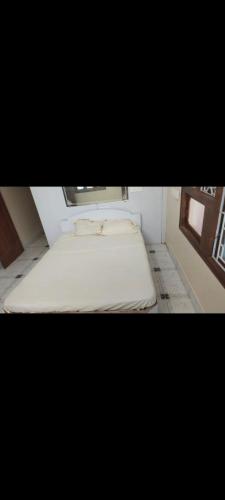 a small bed in a room with a window at Nakwa's mansion in Malpe