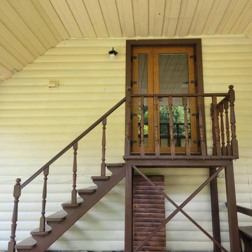 a wooden staircase leading to a door on a house at Садиба Оберіг 2 in Sheshory