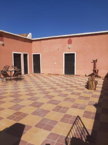 an empty courtyard with a checkered floor in a building at Maison d'hôtes chez l'habitant Asfalou in Ouarzazate