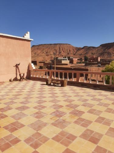 a checkered floor in a building with mountains in the background at Maison d'hôtes chez l'habitant Asfalou in Ouarzazate