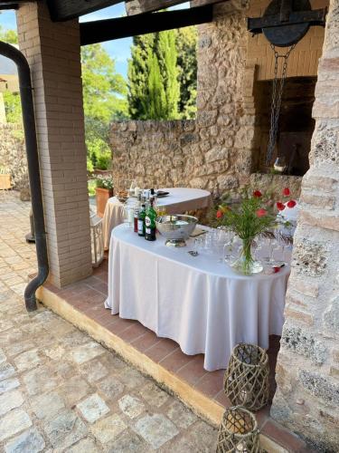 a table with bottles of wine and flowers on it at Relais La Costa Historical Residence in Monteriggioni