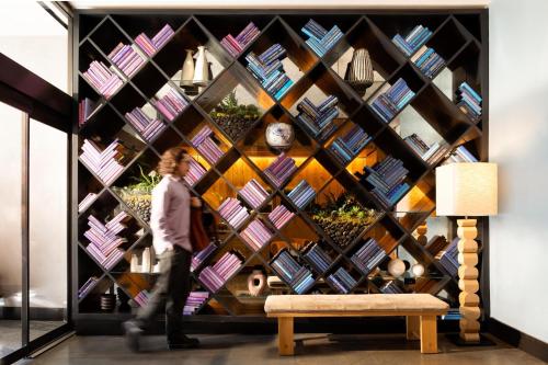 a man walks past a wall of books at Arlo Chicago in Chicago