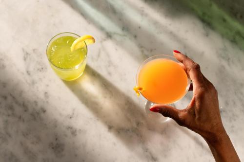 a person holding up a glass of orange juice at Arlo Chicago in Chicago