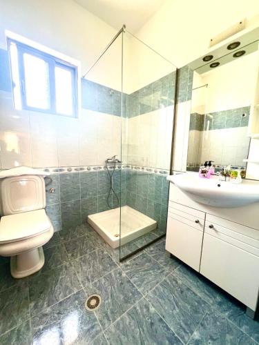 a bathroom with a toilet and a sink and a shower at Villa Lions in Ksamil