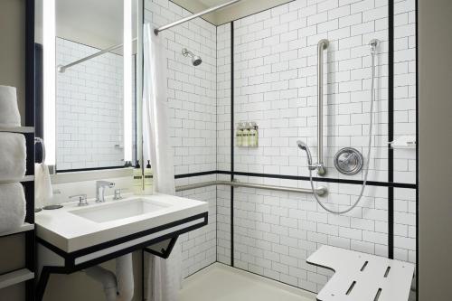 a white bathroom with a sink and a shower at Arlo Chicago in Chicago