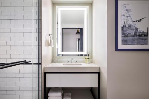 a white bathroom with a sink and a mirror at Arlo Chicago in Chicago