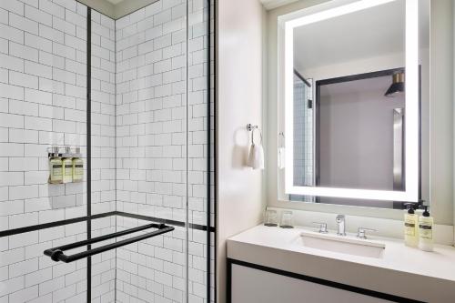 a white bathroom with a sink and a mirror at Arlo Chicago in Chicago