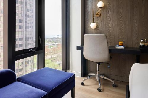 a room with a chair and a desk and window at Arlo Chicago in Chicago