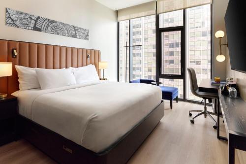 a hotel room with a large bed and a desk at Arlo Chicago in Chicago