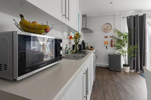a kitchen with a counter top with a microwave at City Centre Studio Apartments - Eden Apartment - Short Stays UK Ltd in Exeter