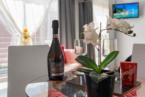 a bottle of wine sitting on a glass table at City Centre Studio Apartments - Eden Apartment - Short Stays UK Ltd in Exeter