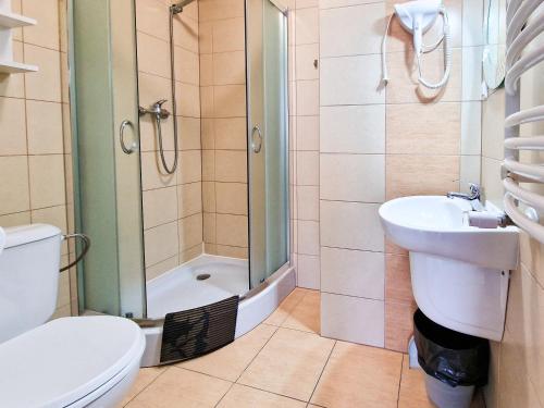 a bathroom with a shower and a toilet and a sink at Villa Sarema in Chłopy
