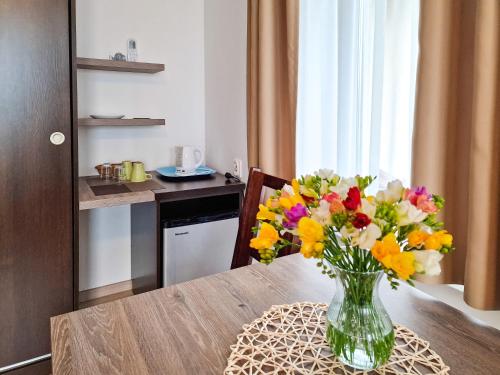 a vase of flowers on a table in a kitchen at Villa Sarema in Chłopy