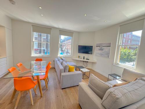 a living room with couches and a table and chairs at Whitfield Street Apartments in London