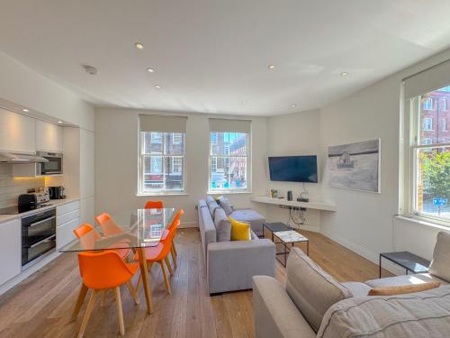 a living room with a couch and a table at Whitfield Street Apartments in London