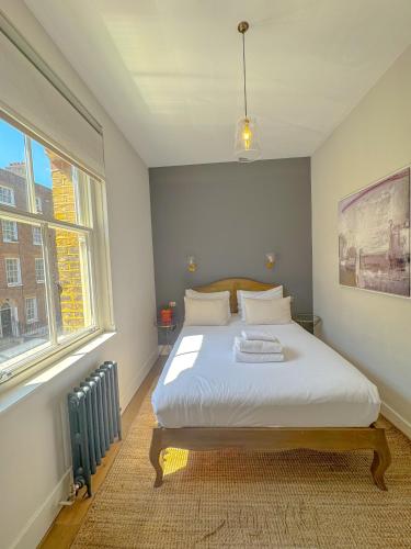 a bedroom with a bed in a room with a window at Whitfield Street Apartments in London