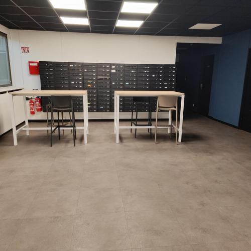 - deux tables et des chaises dans une pièce avec un mur dans l'établissement Studio 74 Rénové et Équipé - Nancy CHRU,CESI,FAC, à Vandœuvre-lès-Nancy