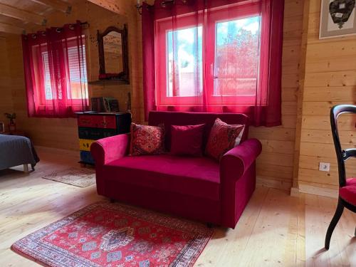 a purple couch sitting in a room with windows at Oasis Des Corbières in Boutenac
