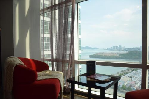 a living room with a chair and a table and a large window at Maritime Suite by Ocean Luxe 2BR Seaview Dryer Water Dispenser in George Town