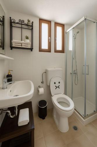 a bathroom with a toilet and a glass shower at Nicolas Beach in Palaiochora