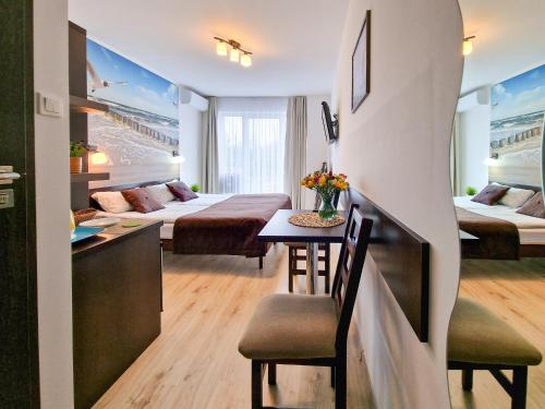 a hotel room with two beds and a table and chairs at Villa Sarema in Chłopy