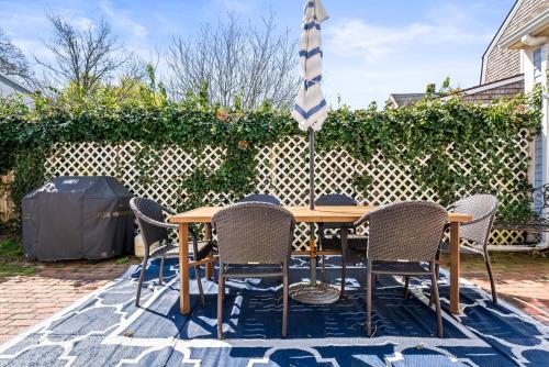 a table with chairs and an umbrella on a patio at Historic Seaside Downtown Mystic Home Walk to Seaport in Stonington