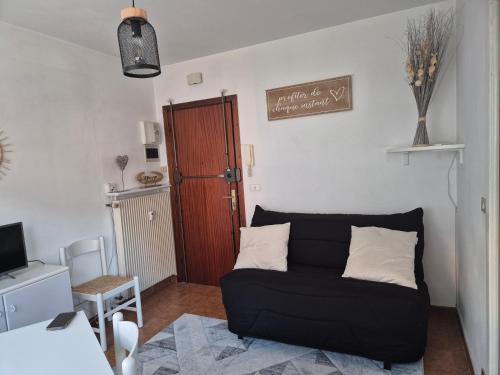 - un salon avec un canapé noir et une porte dans l'établissement Promenade du Soleil 1 promenade reine astride 