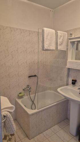 une salle de bain avec une baignoire et un lavabo dans l'établissement Promenade du Soleil 1 promenade reine astride 