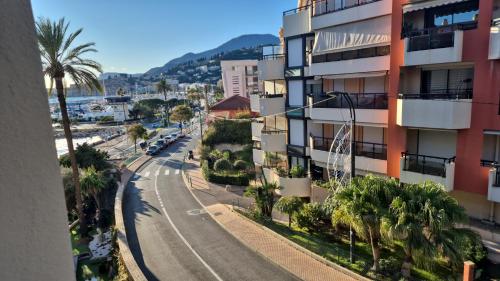 un immeuble avec des palmiers et une rue dans l'établissement Promenade du Soleil 1 promenade reine astride 