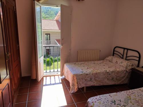 a bedroom with two beds and a door to a balcony at Casa do Poeta in Bubaces