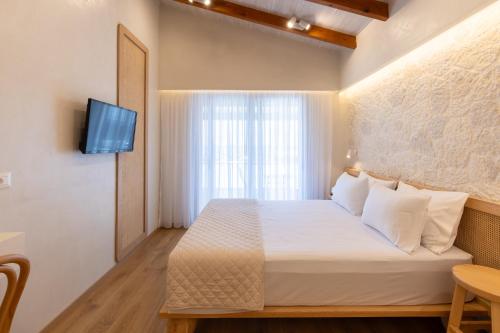 a hotel room with a bed and a television at Dimitri Hotel in Himare
