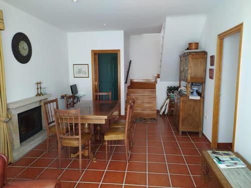 a dining room with a table and chairs and a fireplace at Casa do Poeta in Bubaces