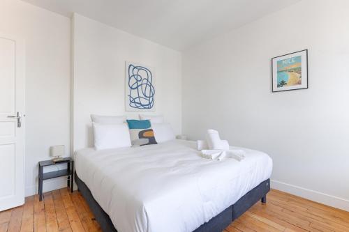 a bedroom with a large bed with white sheets at Appartements à Champigny-Sur-Marne - 30 minutes de Disneyland in Champigny-sur-Marne