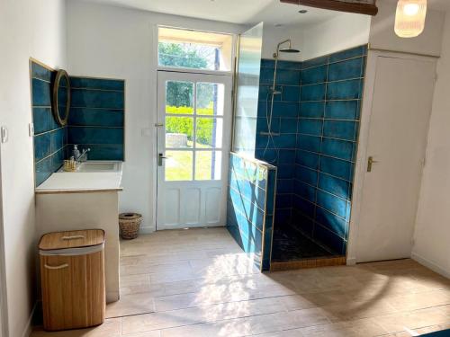 une salle de bain avec un lavabo et une douche avec du carrelage bleu dans l'établissement Whitsundoles Gîte, à Eymet