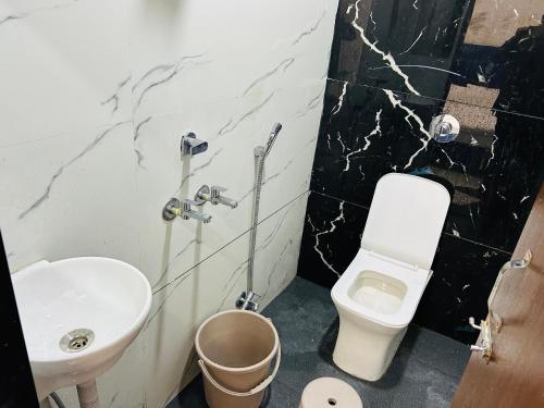 Un baño con lavabo e inodoro en Hotel Shree, en Ujjain