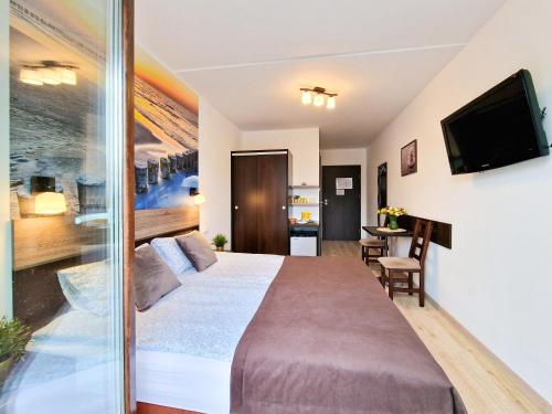 a hotel room with a large bed and a television at Villa Sarema in Chłopy