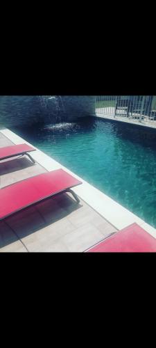 - une piscine d'eau bleue et verte dans l'établissement Villa dusud perpignan, à Pia