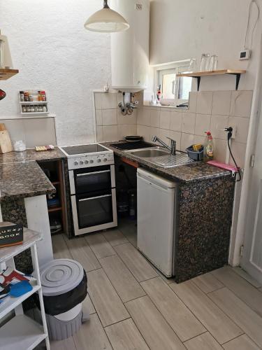 a small kitchen with a sink and a stove at Casa da Abelha- Beehouse in Romão
