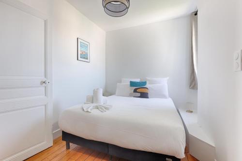 a white bedroom with a bed with white sheets at Appartements à Champigny-Sur-Marne - 30 minutes de Disneyland in Champigny-sur-Marne