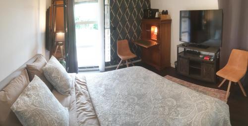 une chambre avec un lit blanc et une télévision dans l'établissement Chambre à la campagne, à Mézières-sur-Couesnon