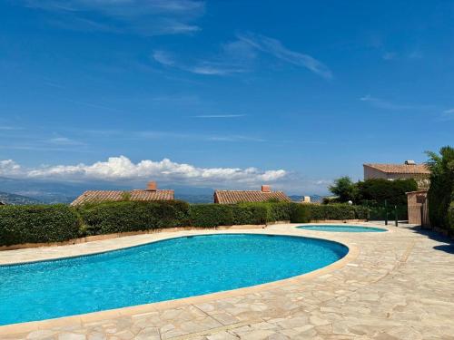 une piscine avec de l'eau bleue dans une cour dans l'établissement Panoramer YourHostHelper, à Théoule-sur-Mer