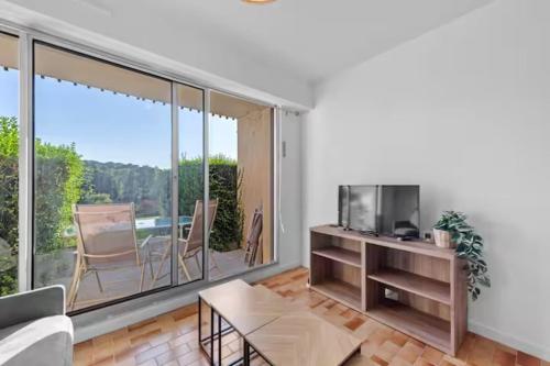 un salon avec un canapé et une télévision dans l'établissement Apartment with area view on the golf of Houlgate, à Houlgate