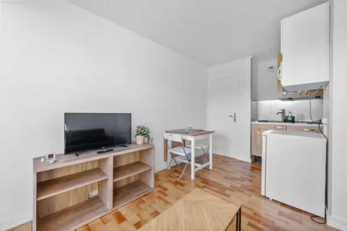 - une cuisine avec une télévision et une table dans une chambre dans l'établissement Apartment with area view on the golf of Houlgate, à Houlgate